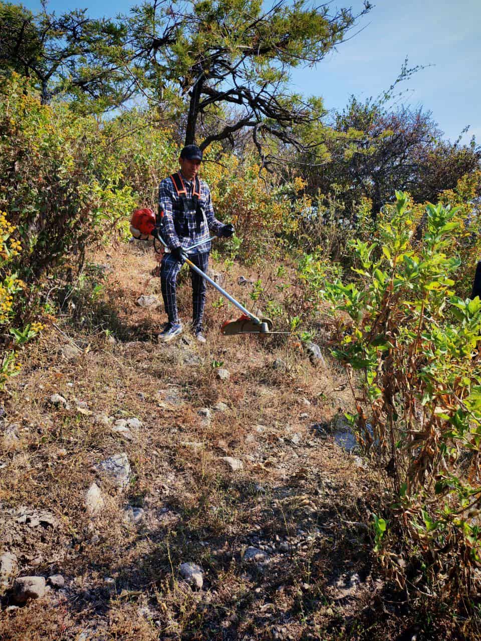 Integrante de la comunidad en mantenimiento de sendero